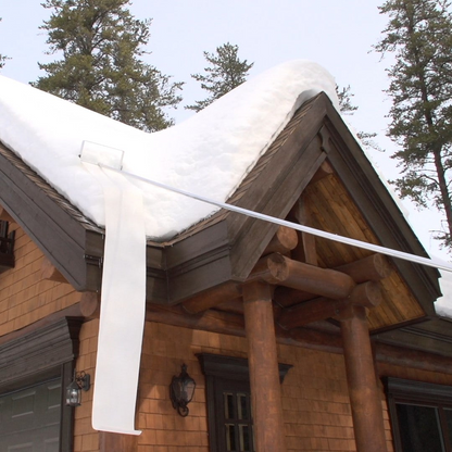 Wooden cabin with snow on the roof in a forest setting